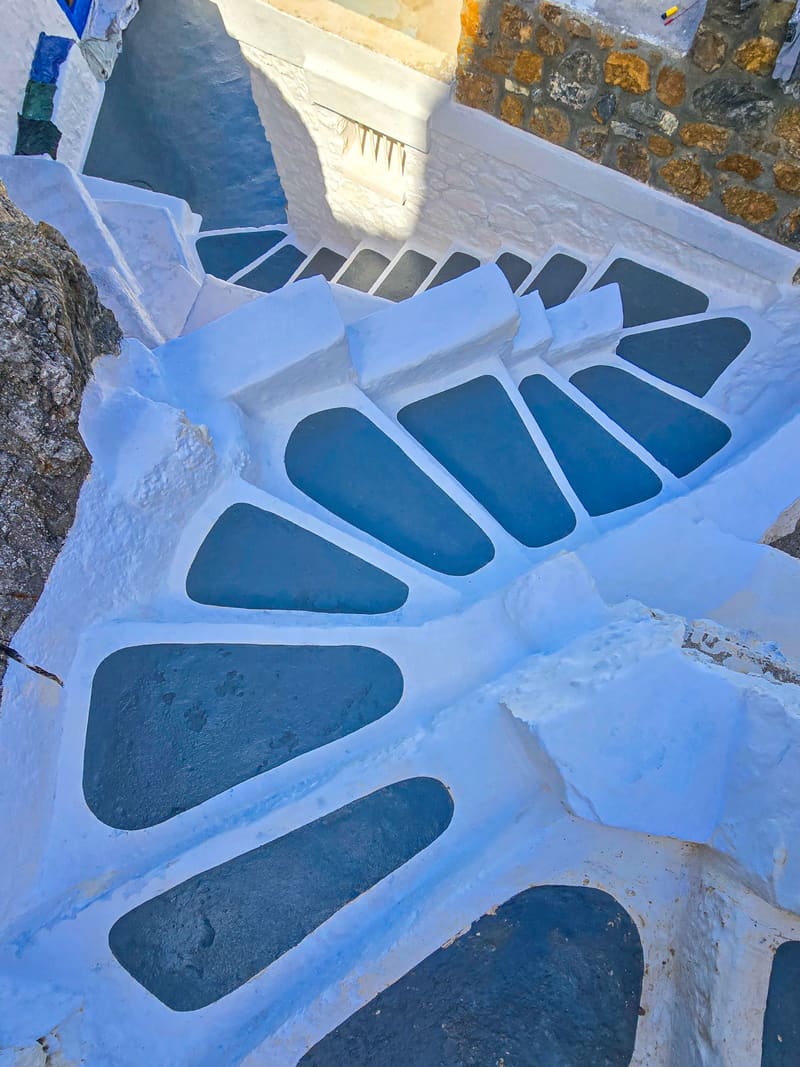 Whitewashed stairs seen from above, each step outlined in white around blue-grey stone.
