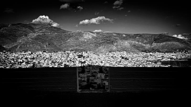 Black and white: a city spread out below mountains.