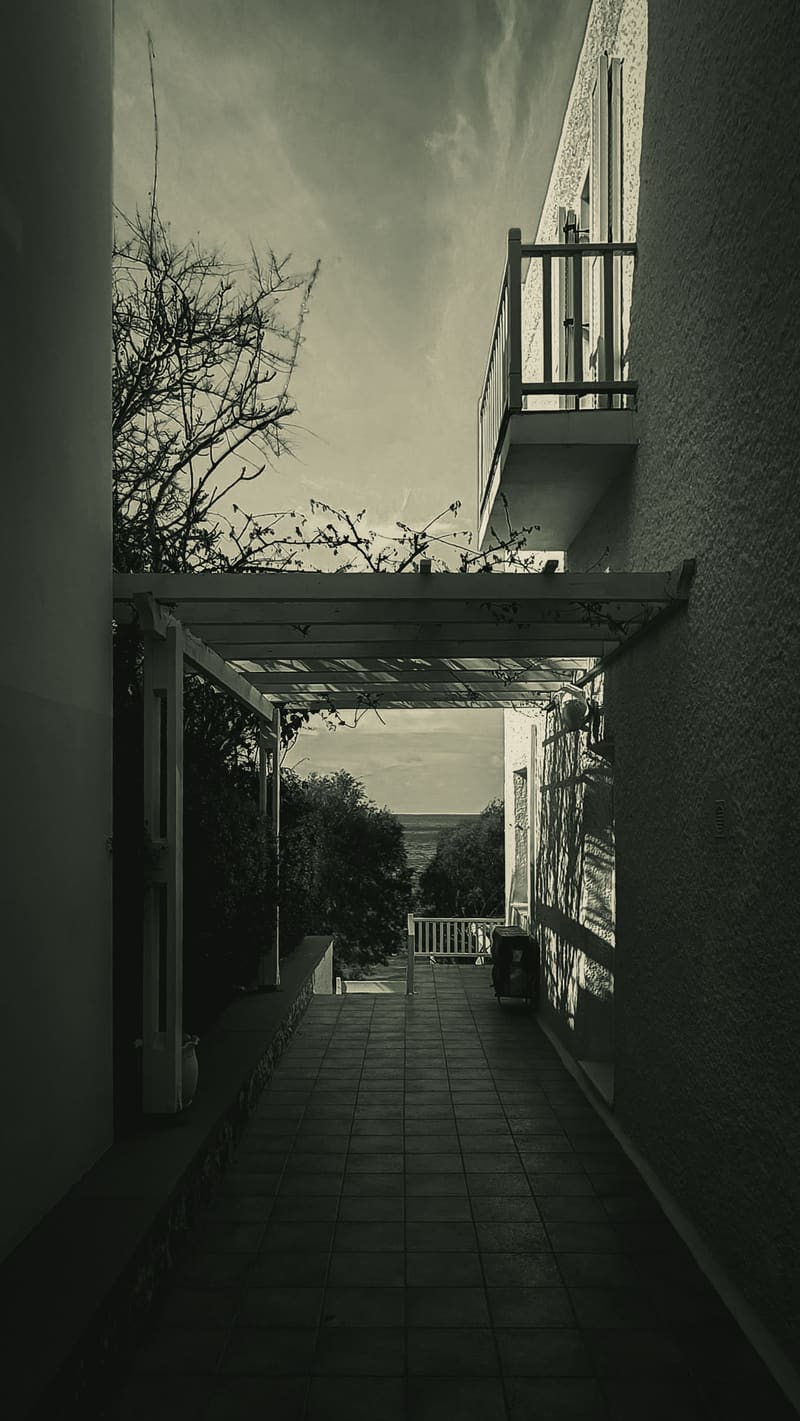 A narrow covered passage between old buildings, in muted tones.