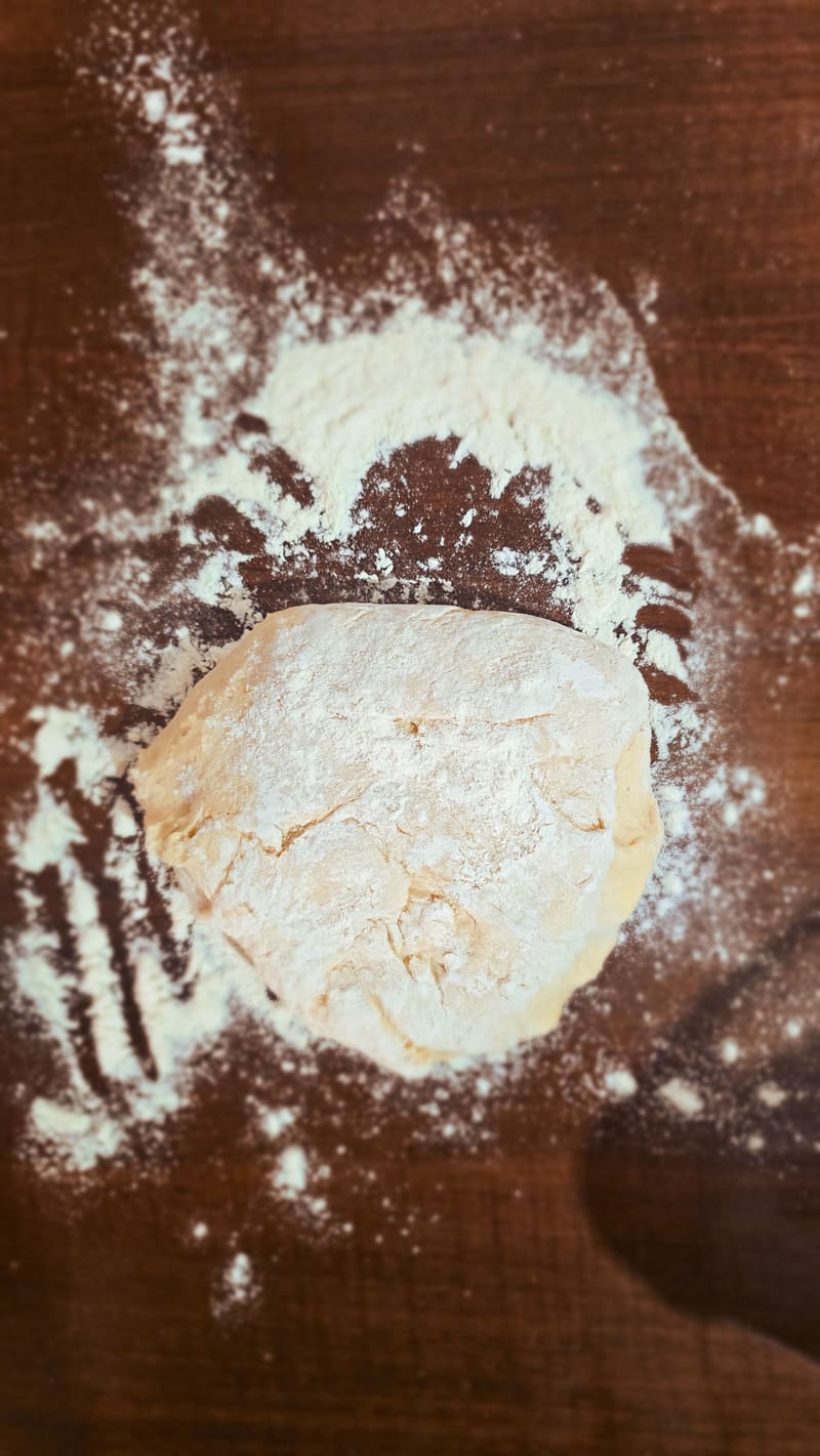 A ball of dough on a floured wooden board.