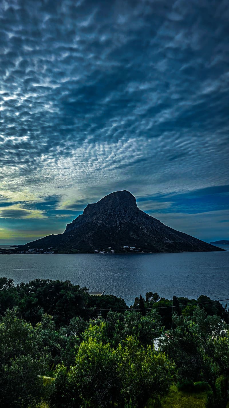 A rocky island under a rippled evening sky.