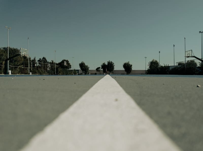 A white painted line on a sports court, seen from ground level.