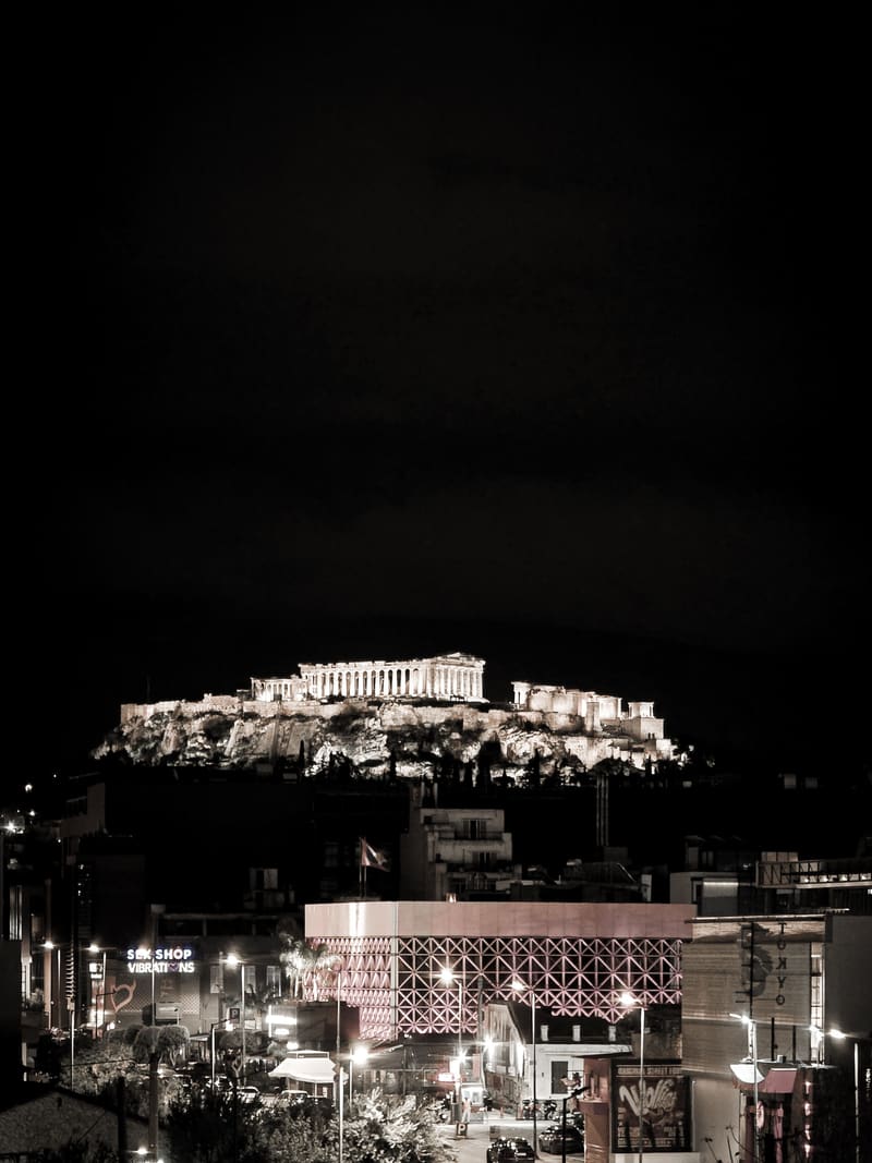 Black and white: an ancient hilltop citadel lit up at night above the city.