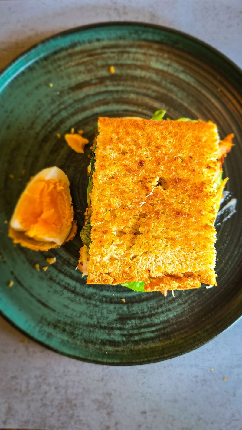 A slice of cake with an orange segment on a dark green plate.